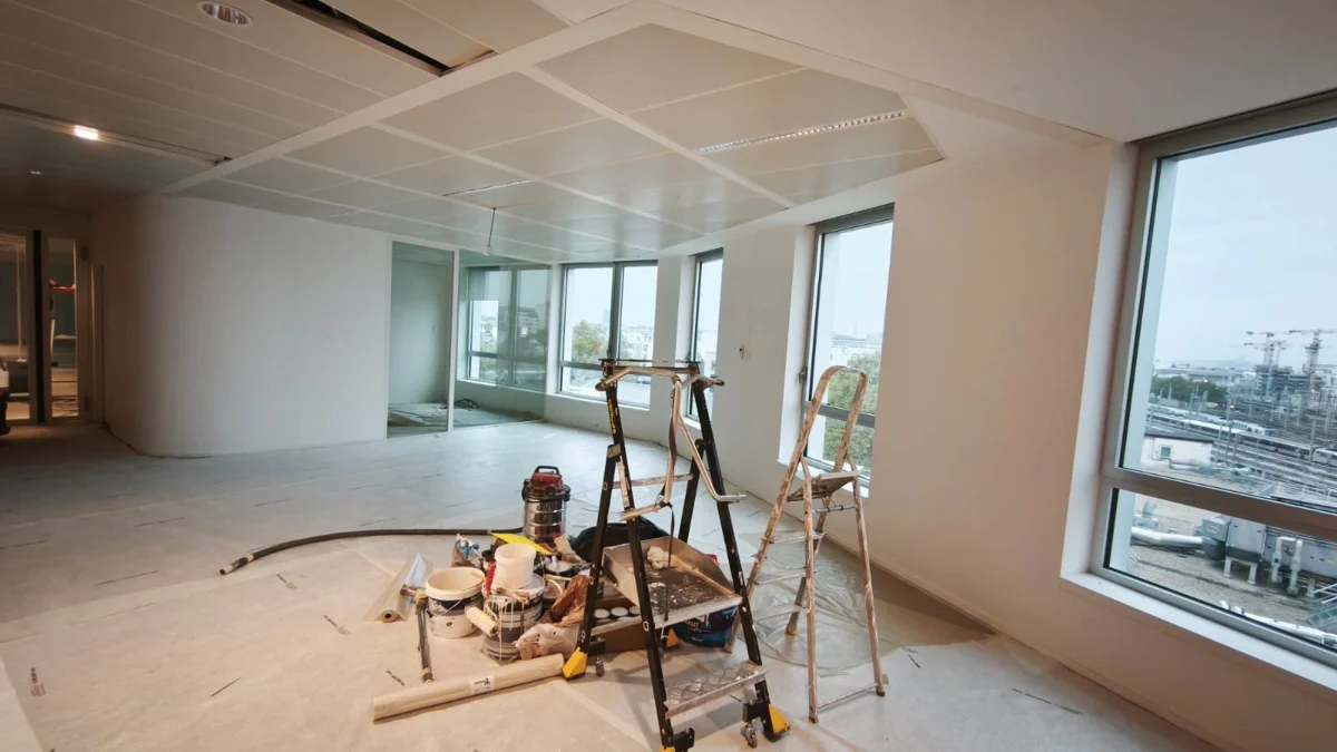 Espace intérieur en travaux, avec matériel et protections au sol