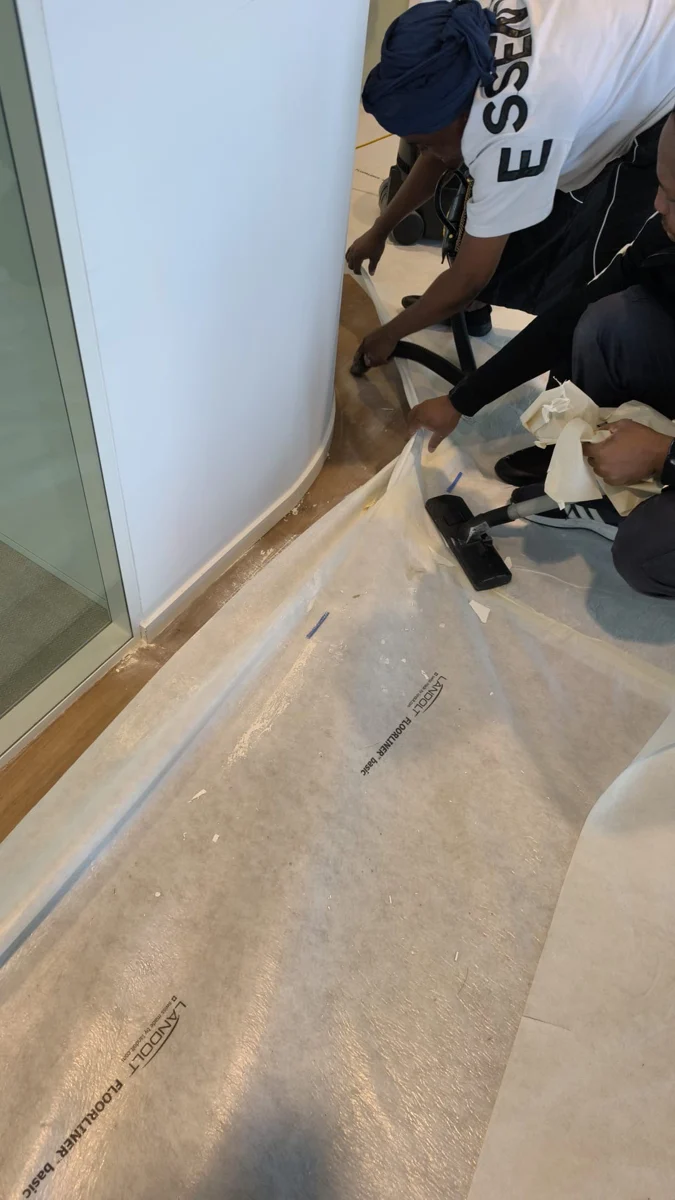 Intervenant retirant des protections au pied d’une cloison vitrée